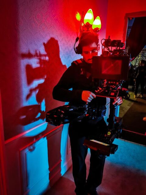 Fabian Meller operating handheld camera in red-lit interior. © Gerhard Riesenhuber
